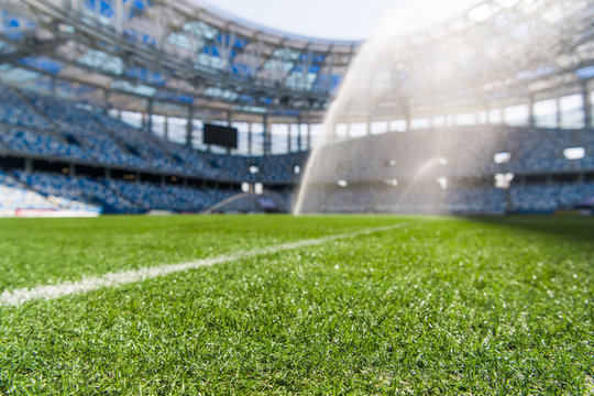 Watering the football field. Close-up macro shot on green grass with white stripe.