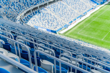 Naklejka premium Blue seats with handrails on the tribune of the stadium.