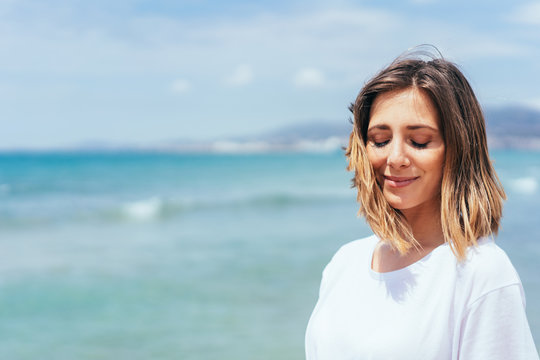 Relaxed young woman with closed eyes at beach