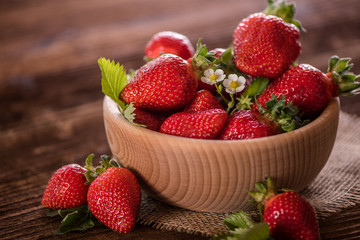 strawberries in wooden bowl on wood table