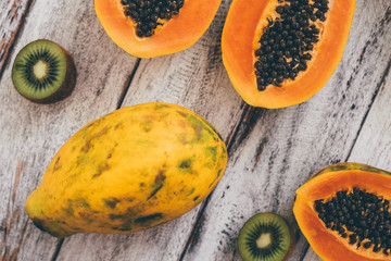 tropical fruits papaya kiwi banana pomegranate mango on wooden table