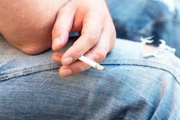 Cigarette in the hands of a seated man