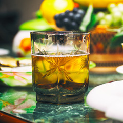 A glass of drink on the table with fruit