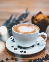 Closeup of decorated coffe with coffee beans, cookie and flowers on background
