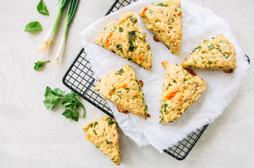 Savory scones with feta mozarella and green herbs on a wire rack. White stone background. - 207745183