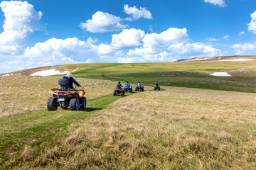 Friends driving off-road with quad bike or ATV and UTV vehicles