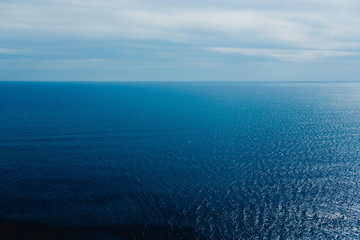 Calm blue sea without waves seen from a cliff with room for text