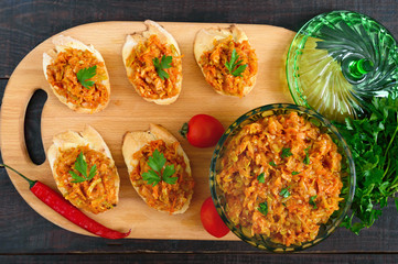 Squash caviar on a crispy baguette on a dark wooden table. Sandwiches with stewed vegetables. Vegan appetizer.