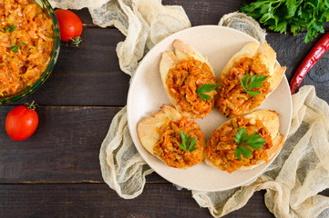 Squash caviar on a crispy baguette on a dark wooden table. Sandwiches with stewed vegetables. Vegan appetizer.
