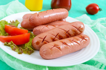 Delicious juicy grilled sausages on a plate, vegetables, ketchup and mustard on a bright background.