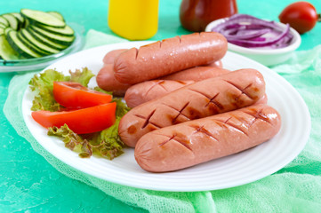 Delicious juicy grilled sausages on a plate, vegetables, ketchup and mustard on a bright background.