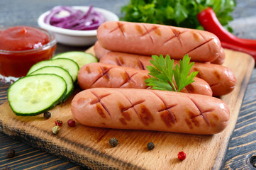 Juicy grilled sausages, sauce and fresh vegetables. Sausages for hot dog. Street food.
