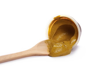 Yellow mustard sauce in plastic cup, container with wooden spoon isolated on white background