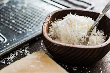 Fresh grated parmesan cheese in wooden bowl