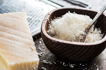 Fresh grated parmesan cheese in wooden bowl