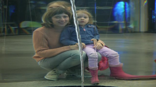 Family enjoy watching liquid whirlpool exposition distorts space