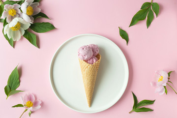 Spring or summer mood concept. Flat-lay of waffle sweet cone with berryy over pastel light pink background, top view.