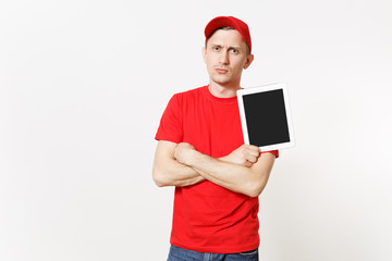 Delivery man in red uniform isolated on white background. Male in cap, t-shirt, jeans working as courier or dealer, holding tablet pc computer with blank empty screen. Copy space for advertisement.