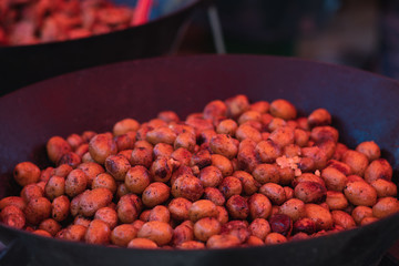 Potatoes are prerpaping in the wok on the food festival. street food business