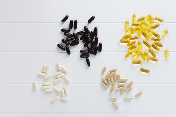 Set of Omega 3 capsules, assorted pharmaceutical medicine pills, tablets on white wooden table. Pills background. Health care.Top view