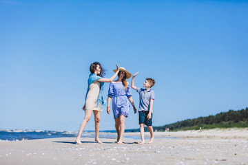 Mother with children walking by the sea