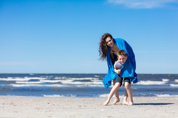 Fototapeta na wymiar Older sister holding her little brother on the beach.