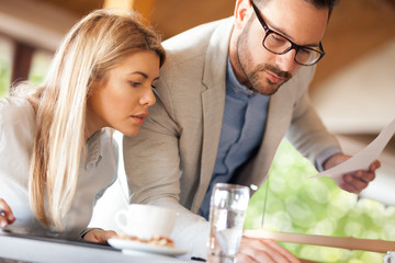 young businessperson sitting in urban café with important document