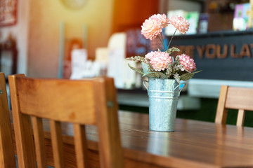 Fake flower in pot on wooden table