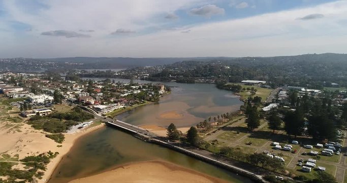 Shallow lagoon of Narrabeen lake at the entrance to Pacific ocean and surrounding suburbs and local houses and streets.
