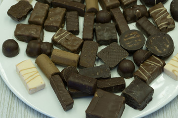 Assorted chocolate sweets with dark, milk and white chocolate, selective focus .
