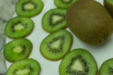 Fototapeta premium Fresh organic kiwi fruit sliced. Food frame with copy space for your text. Banner. Green kiwi circles background.