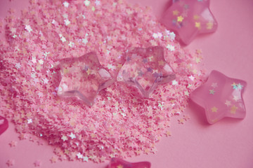 Pink stars lying in glitters. Abstract background