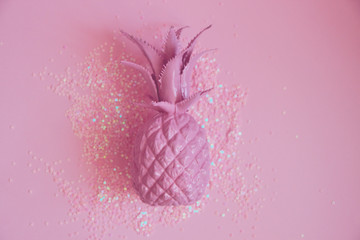 Pink pineapple lying in glitters. Concept minimal photo. Top view