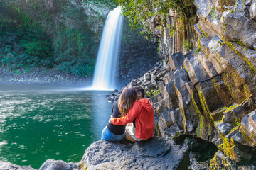 Couple kissing under the Bassin La Paix waterfall in Reunion Island © Zamir