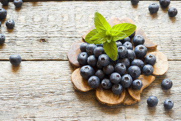 Blueberries on old wooden dishes, space for text