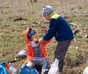 little boy gives girl bouquet of wild flowers. Hiking  outdoor portrait