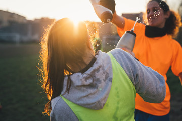 Football player squirting water onto each others
