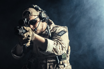 Special forces soldier with rifle on dark background