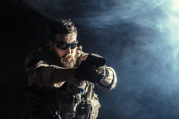 Special forces soldier with rifle on dark background