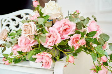 Close up of lush rose flowers on top of white grand piano, copy space