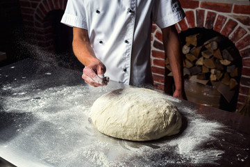 chef making dough for pizza. Man hands preparing bread. Concept of baking and patisserie