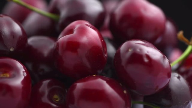 Cherry. Organic ripe cherries rotated closeup over black background. Rotation 4K UHD video 3840X2160
