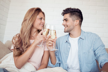 Young couple drink wine in their living room