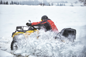 Fototapeta na wymiar Winter race on an ATV on snow in the forest.