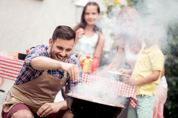 Young family make barbecue at their home