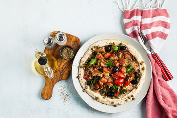 fresh Greek dakos salad on a layer of hummus. light vegan summer nutritious recipe