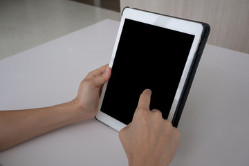 white tablet with a blank screen in the hands