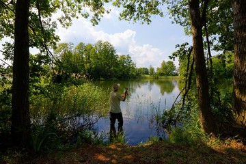 Fototapeta na wymiar Fisherman in the lake during sunny day