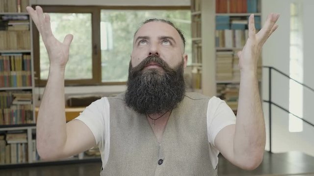 Mind blown reaction of a non conformist young man looking at the celling and expressing himself through hand gestures