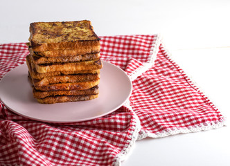 fried French toast on a ceramic pink plate
